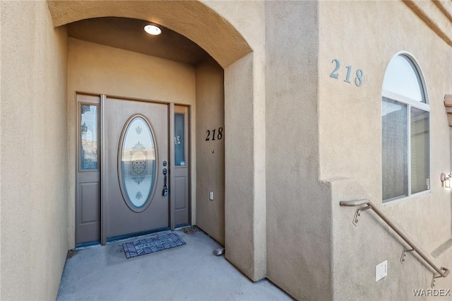 entrance to property featuring stucco siding