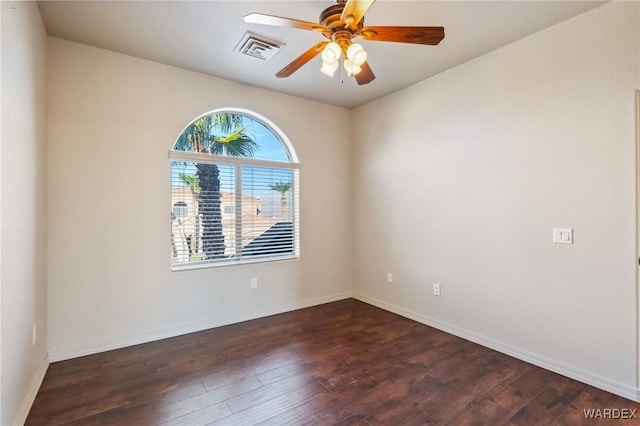 empty room with dark wood-style floors, baseboards, visible vents, and ceiling fan