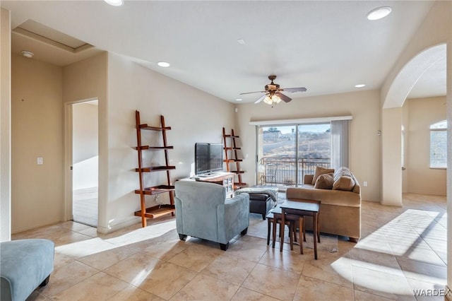 living area featuring arched walkways, a ceiling fan, a wealth of natural light, and recessed lighting