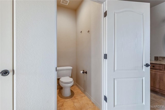 bathroom with toilet, baseboards, visible vents, and tile patterned floors