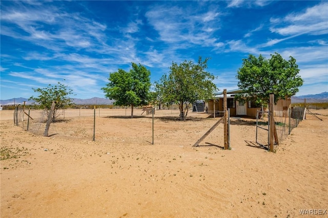 exterior space featuring fence, a rural view, and a mountain view