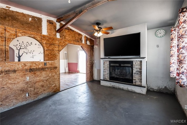 unfurnished living room featuring a glass covered fireplace, lofted ceiling, a ceiling fan, and finished concrete floors