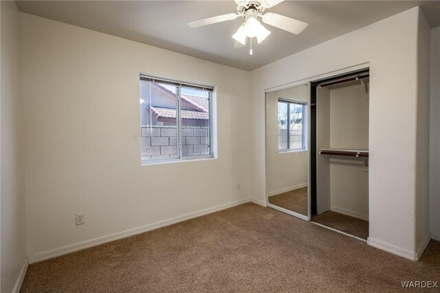 unfurnished bedroom featuring carpet floors, ceiling fan, baseboards, and a closet