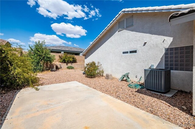 exterior space with stucco siding, a patio, and central air condition unit