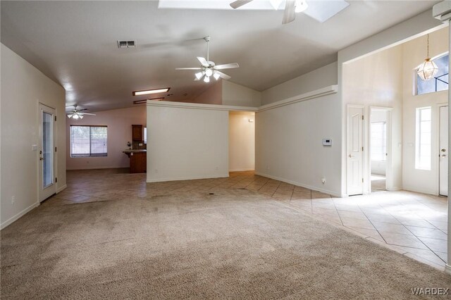 spare room featuring light carpet, light tile patterned floors, visible vents, a ceiling fan, and high vaulted ceiling