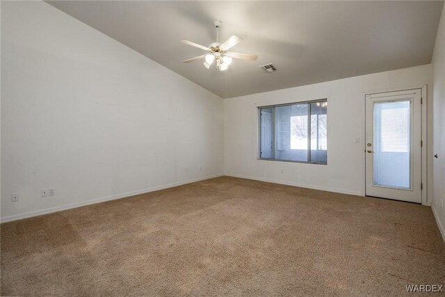 carpeted empty room featuring a ceiling fan, lofted ceiling, visible vents, and baseboards