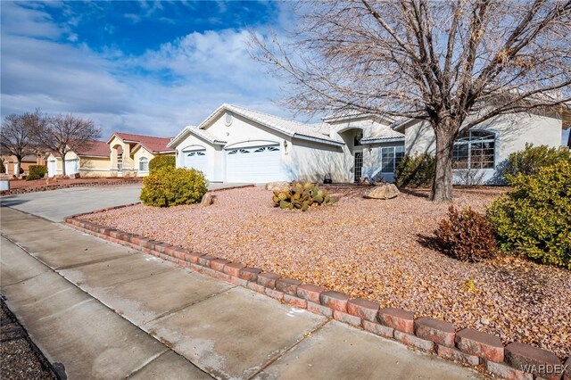 view of front of home with driveway, a garage, and stucco siding