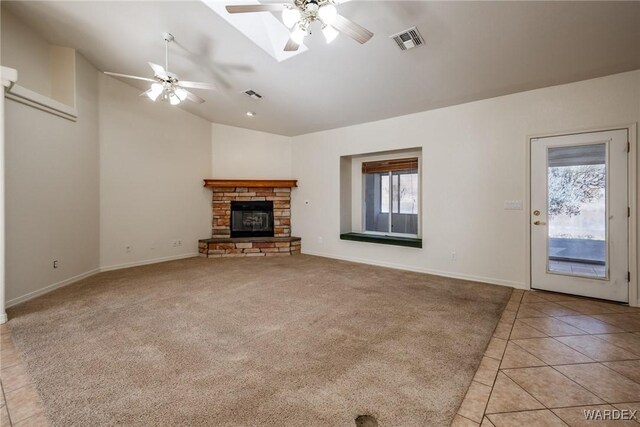 unfurnished living room featuring light tile patterned floors, plenty of natural light, visible vents, and light colored carpet