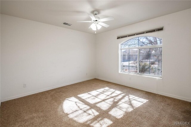 unfurnished room with light colored carpet, visible vents, ceiling fan, and baseboards