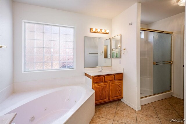 full bathroom featuring a jetted tub, a stall shower, tile patterned flooring, and vanity