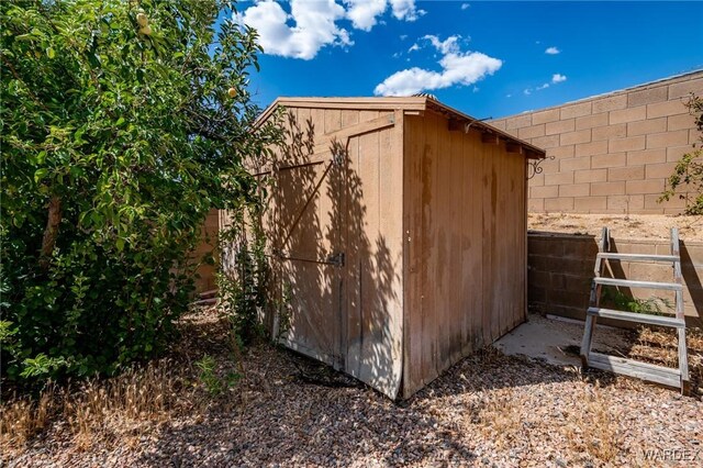 view of shed featuring fence