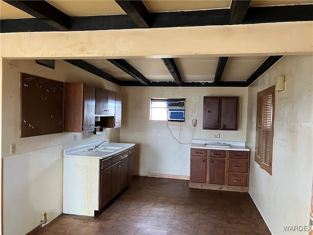 kitchen with a sink, beam ceiling, and light countertops