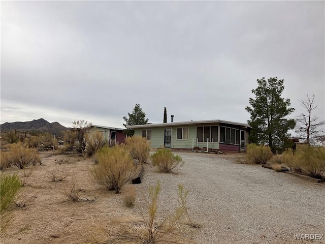 view of front facade featuring a mountain view and a sunroom