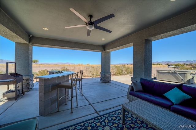 view of patio with an outdoor living space, a mountain view, outdoor dry bar, and ceiling fan