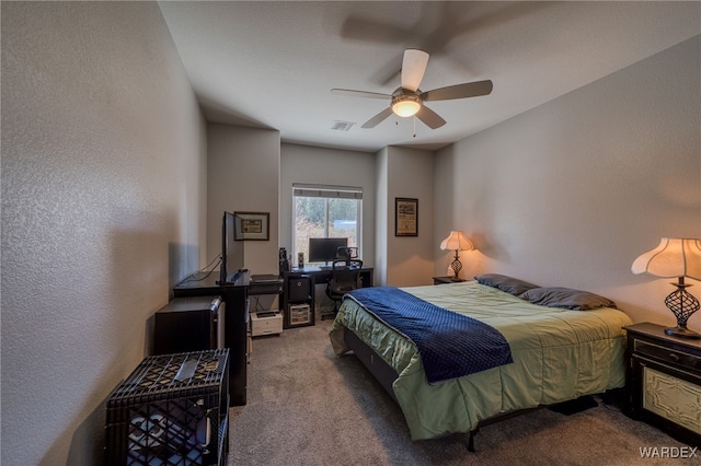 bedroom featuring visible vents, carpet flooring, a ceiling fan, and a textured wall