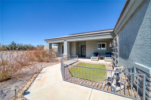 exterior space with stucco siding, fence, and a patio area