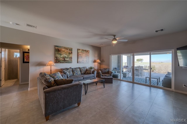 tiled living area with visible vents, baseboards, and ceiling fan