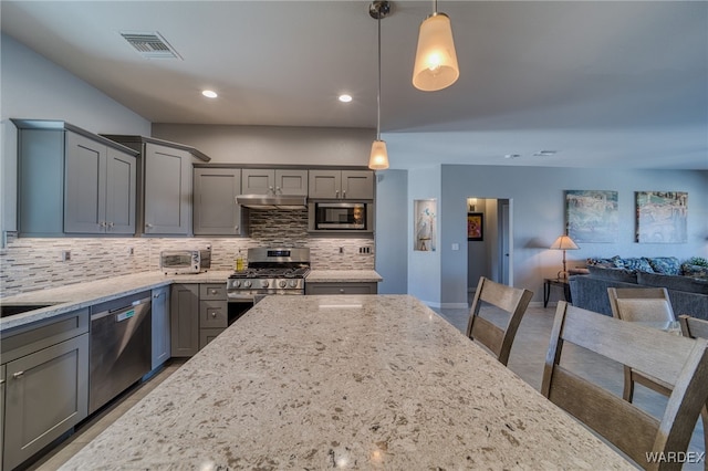 kitchen featuring tasteful backsplash, visible vents, light stone counters, gray cabinets, and appliances with stainless steel finishes