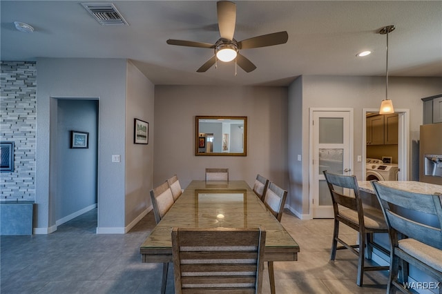 dining room with visible vents, baseboards, a ceiling fan, and washing machine and clothes dryer