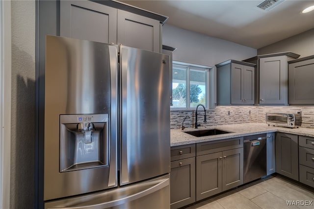 kitchen with a sink, visible vents, appliances with stainless steel finishes, and gray cabinetry