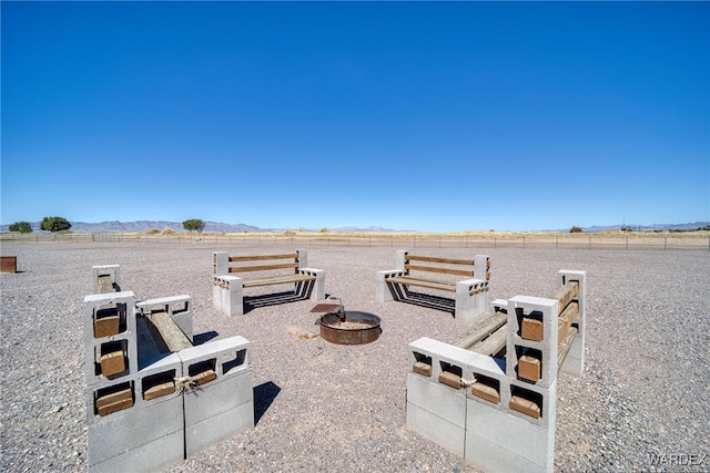 view of patio / terrace featuring a mountain view, a fire pit, and a rural view