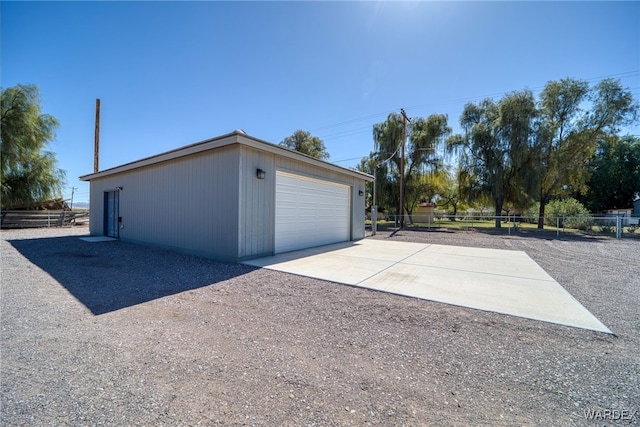 detached garage featuring fence