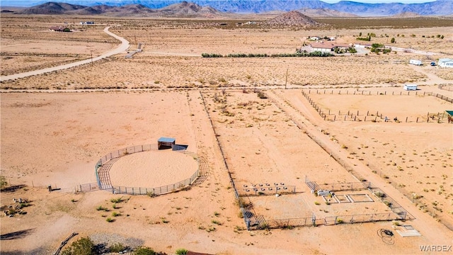 drone / aerial view featuring a rural view, view of desert, and a mountain view