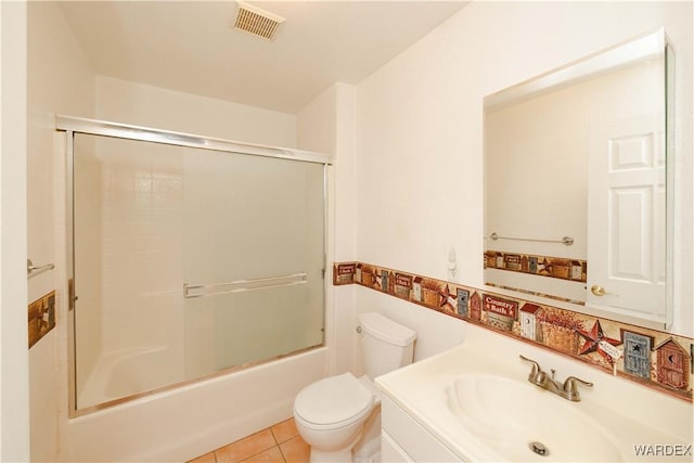 bathroom featuring tile patterned flooring, visible vents, toilet, vanity, and combined bath / shower with glass door