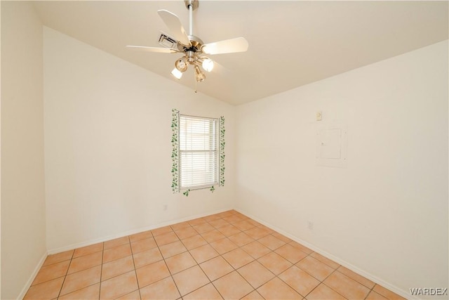 spare room with lofted ceiling, visible vents, light tile patterned floors, baseboards, and ceiling fan