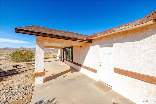 exterior space with stucco siding and a patio area