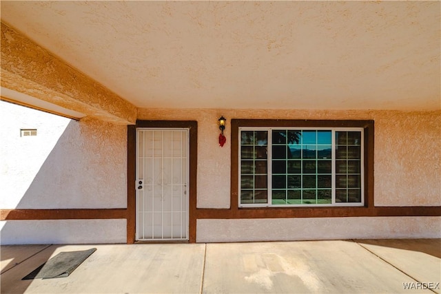 view of exterior entry featuring stucco siding