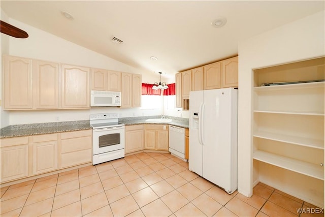 kitchen featuring light brown cabinetry, vaulted ceiling, light tile patterned floors, a sink, and white appliances