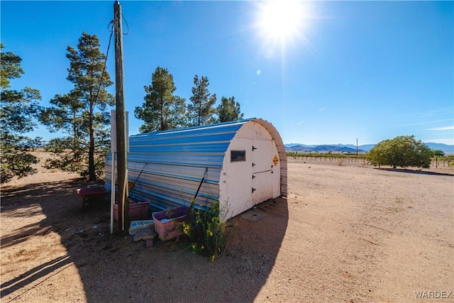 view of outbuilding featuring a mountain view and a rural view