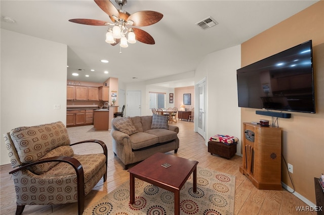 living room featuring recessed lighting, visible vents, light wood-style flooring, a ceiling fan, and baseboards