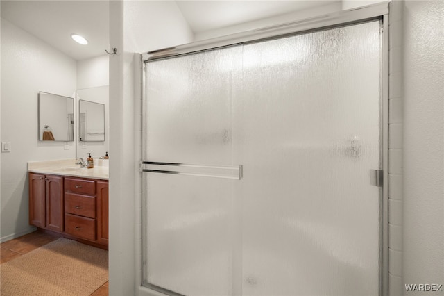 full bath with tile patterned flooring, an enclosed shower, and vanity