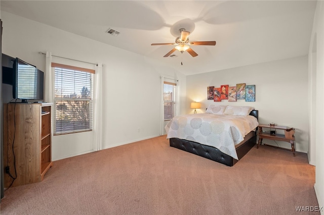 carpeted bedroom featuring a ceiling fan, visible vents, and multiple windows