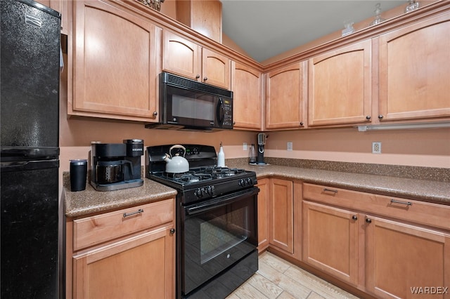 kitchen with lofted ceiling, black appliances, and dark countertops