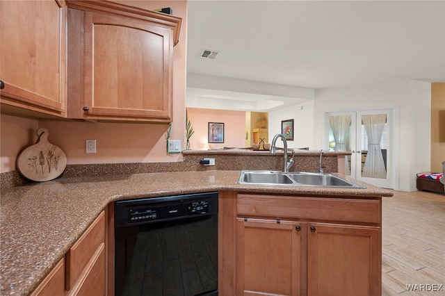 kitchen with black dishwasher, light wood-style flooring, open floor plan, a peninsula, and a sink