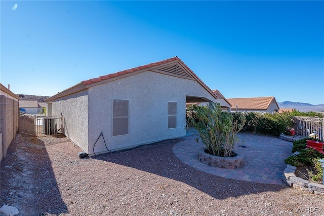 view of property exterior with a patio area, a fenced backyard, a mountain view, and stucco siding