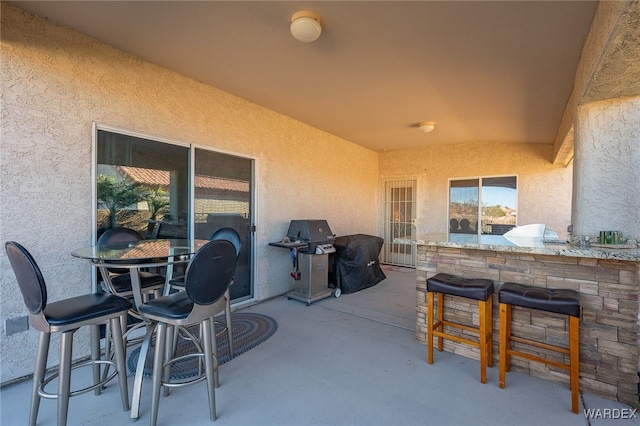 view of patio featuring outdoor dry bar and grilling area