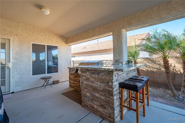 view of patio / terrace featuring exterior bar, a grill, fence, and area for grilling