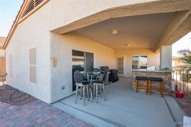 view of patio with outdoor dry bar and grilling area