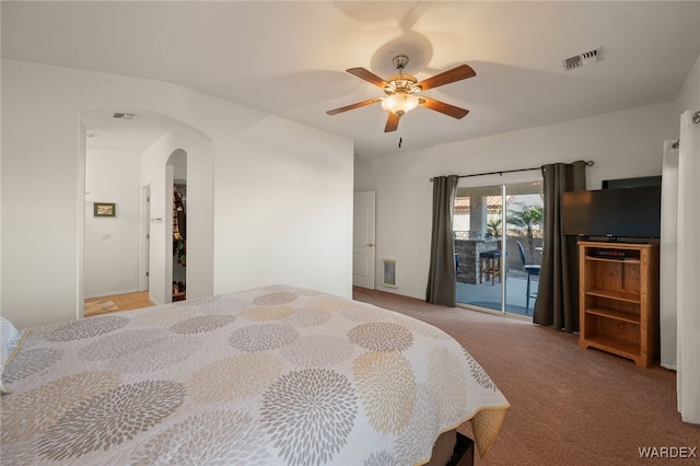 bedroom featuring visible vents, arched walkways, a ceiling fan, access to exterior, and carpet