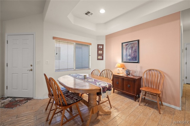 dining room featuring recessed lighting, visible vents, baseboards, light wood-type flooring, and a tray ceiling