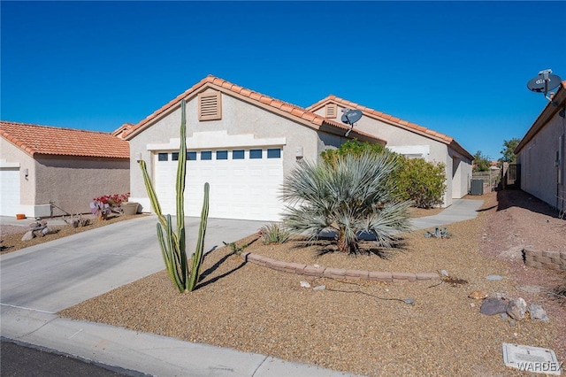 view of front of house featuring a tile roof, driveway, an attached garage, and stucco siding