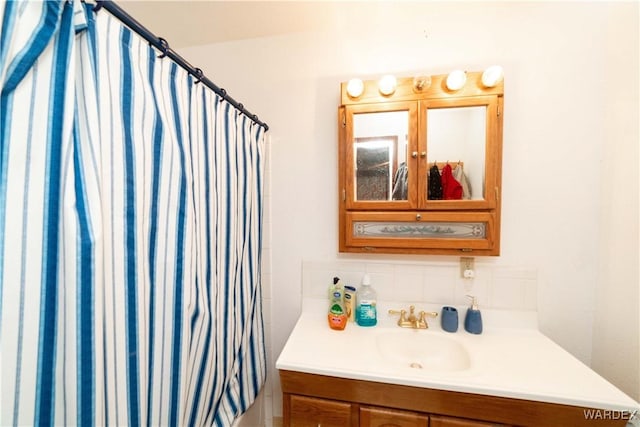 full bathroom with a shower with shower curtain, vanity, and decorative backsplash