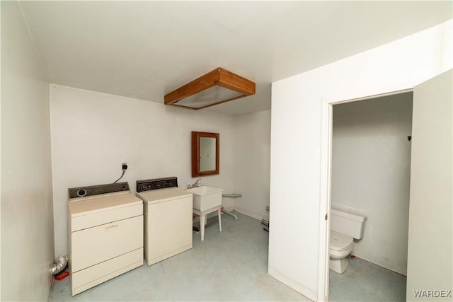 clothes washing area with laundry area, washer and clothes dryer, and a sink