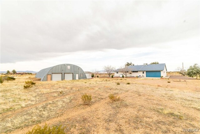 view of yard with an outbuilding, an outdoor structure, and a detached garage