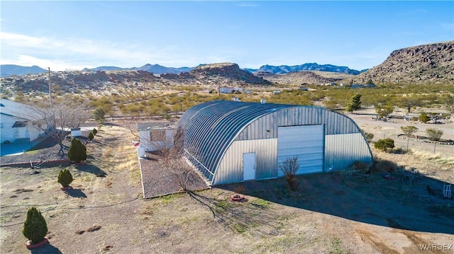 view of pole building featuring dirt driveway and a mountain view