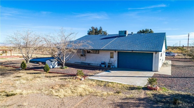 view of front of home featuring concrete driveway, a shingled roof, an attached garage, and stucco siding